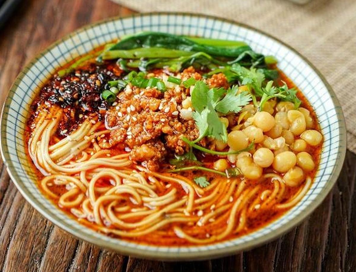 Chongqing Xiaomian — thin alkaline noodles under a slick of red chili oil, the breakfast the city runs on