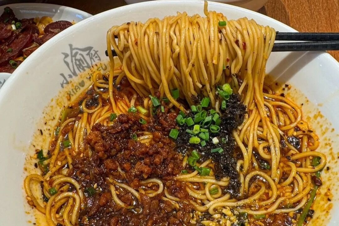 Dan Dan Noodles — closeup of the glossy chili oil and sesame-coated noodles