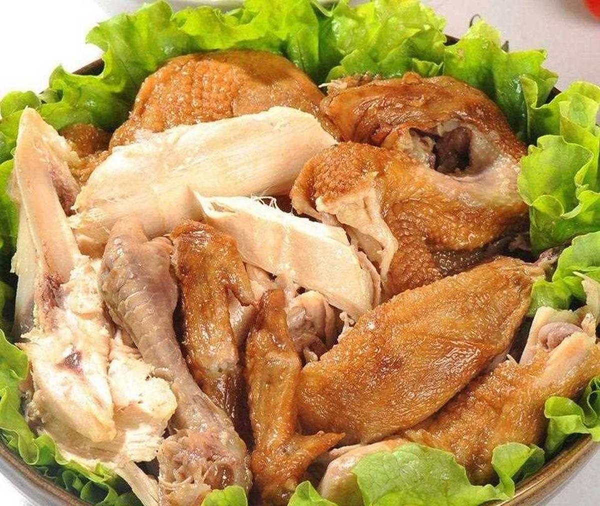 Dezhou braised chicken served — chopped braised chicken pieces with glossy skin on a bed of lettuce, eaten cold at the table
