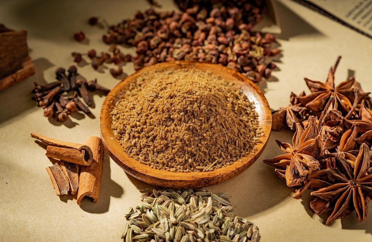 Five-spice powder — a reddish-brown blend of star anise, cloves, cinnamon, Sichuan peppercorn, and fennel