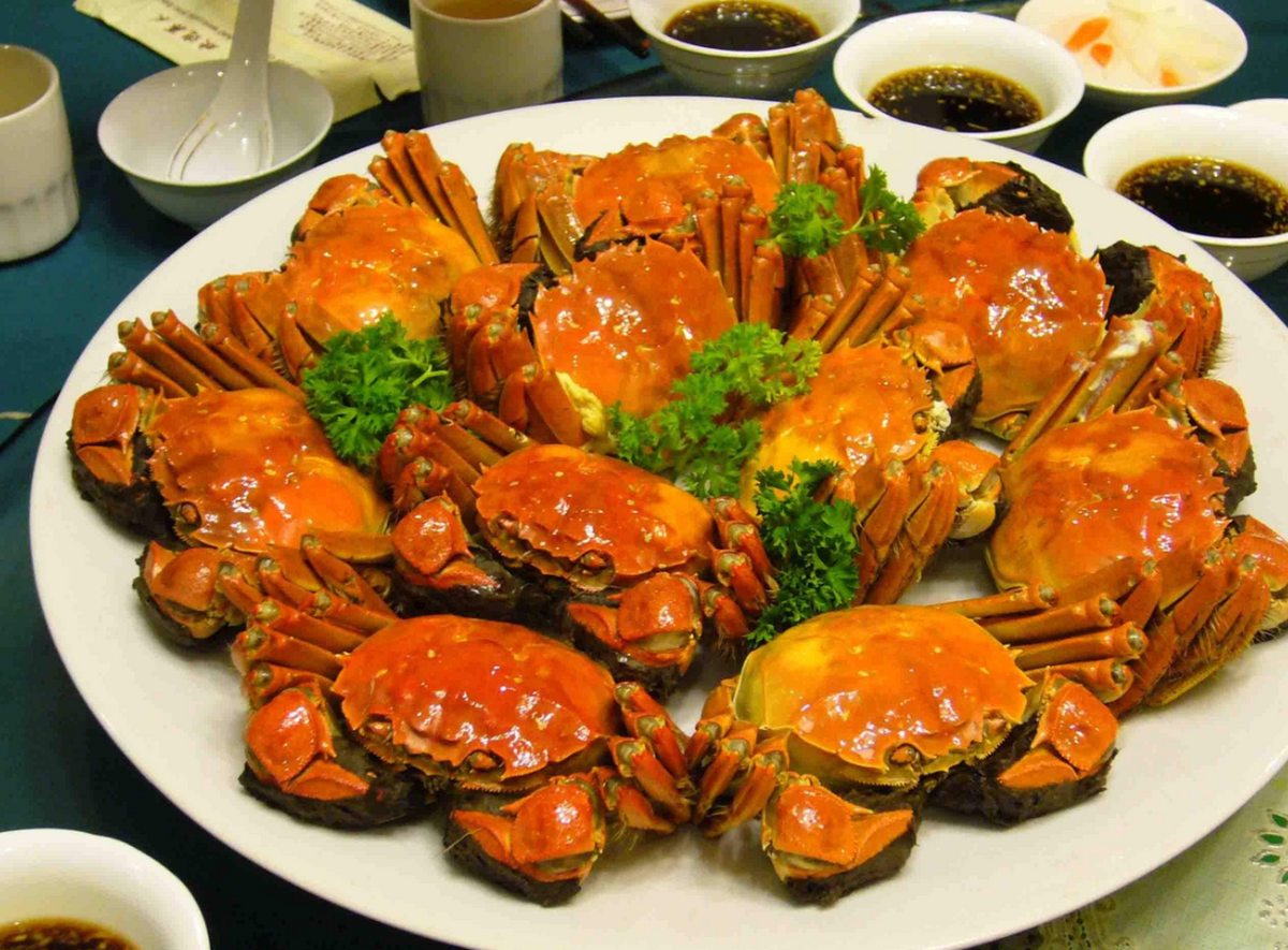 Hairy crabs on the table with saucers of Zhenjiang black vinegar and shredded ginger