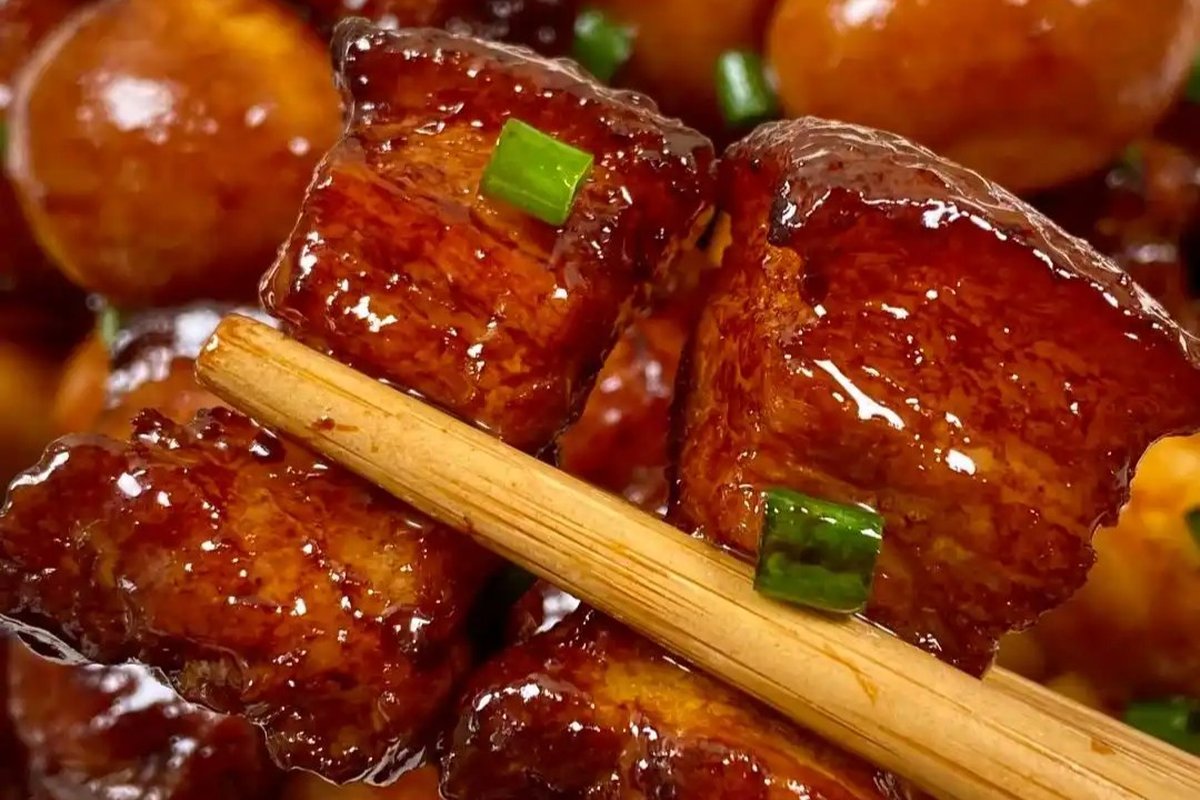 Close-up — hóngshāo ròu in a dark clay pot, sauce glossy, star anise visible