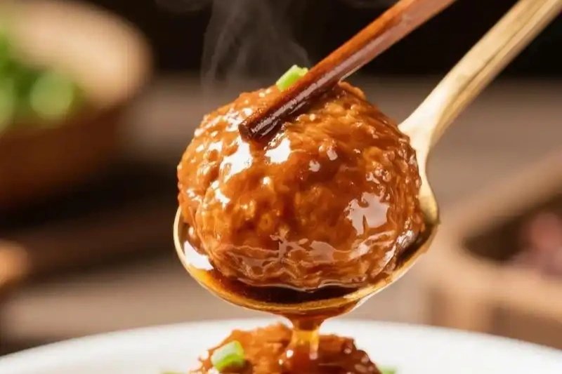Lion’s head meatballs in a clay pot, napa cabbage wrapped around them, chopsticks reaching in