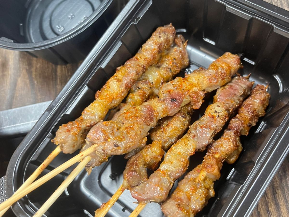 Lamb skewers off the fire, fat and lean still alternating on the stick