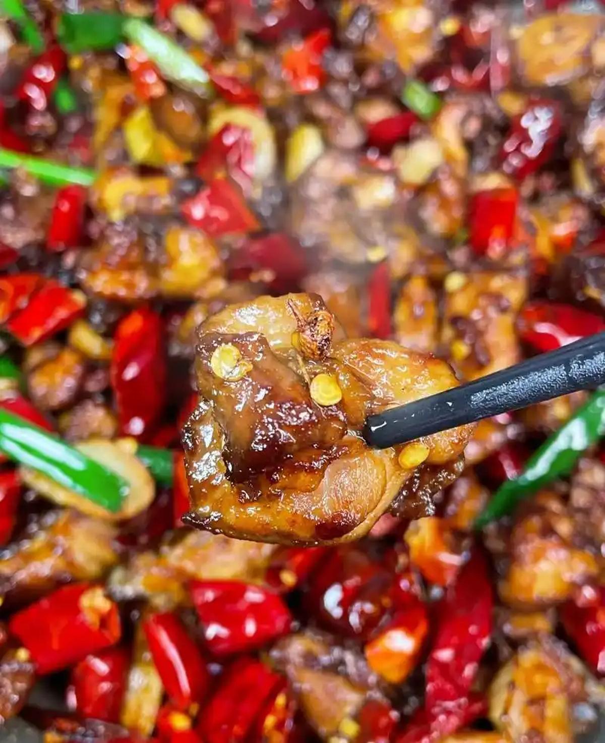 Laziji — close-up of crispy chicken nuggets peeking through a dense layer of dried red chilies
