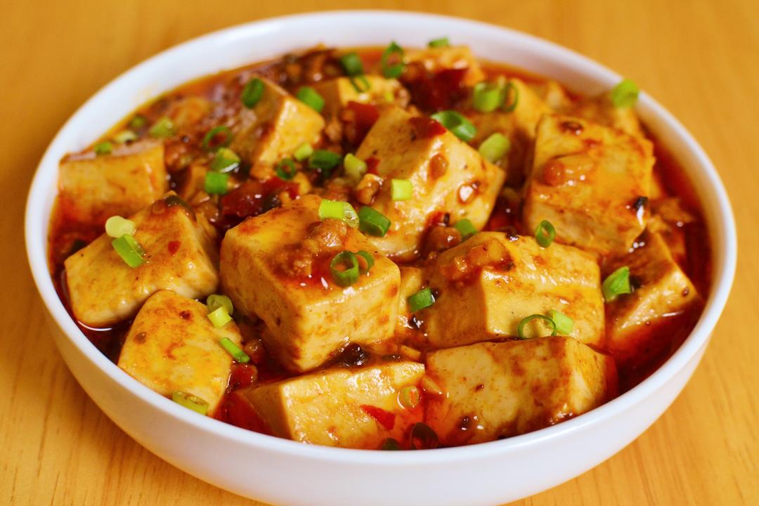 Mapo Tofu — silky tofu cubes in a fiery red pool of chili oil and doubanjiang, topped with freshly ground Sichuan peppercorns