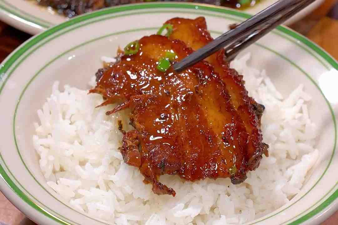 Mei Cai Kou Rou served in a traditional bowl with rice on the side