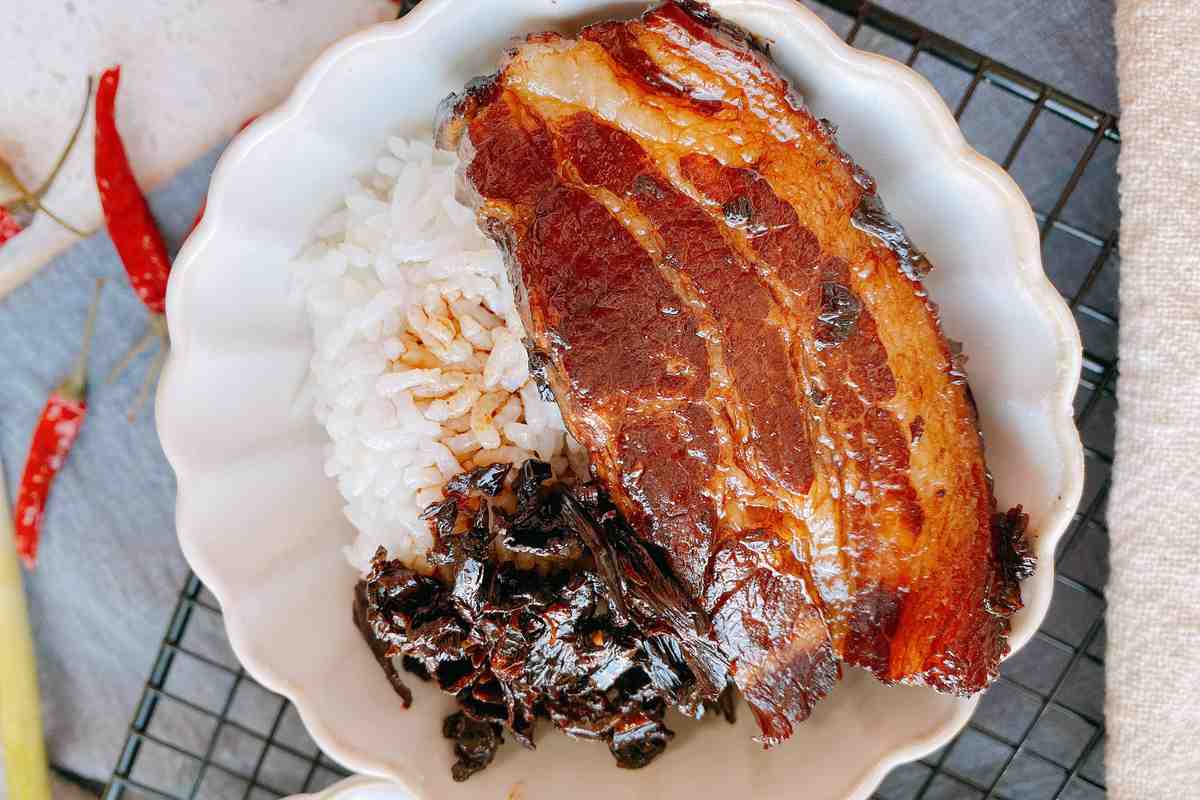 Mei Cai Kou Rou over rice — the dark sauce seeping into the grains