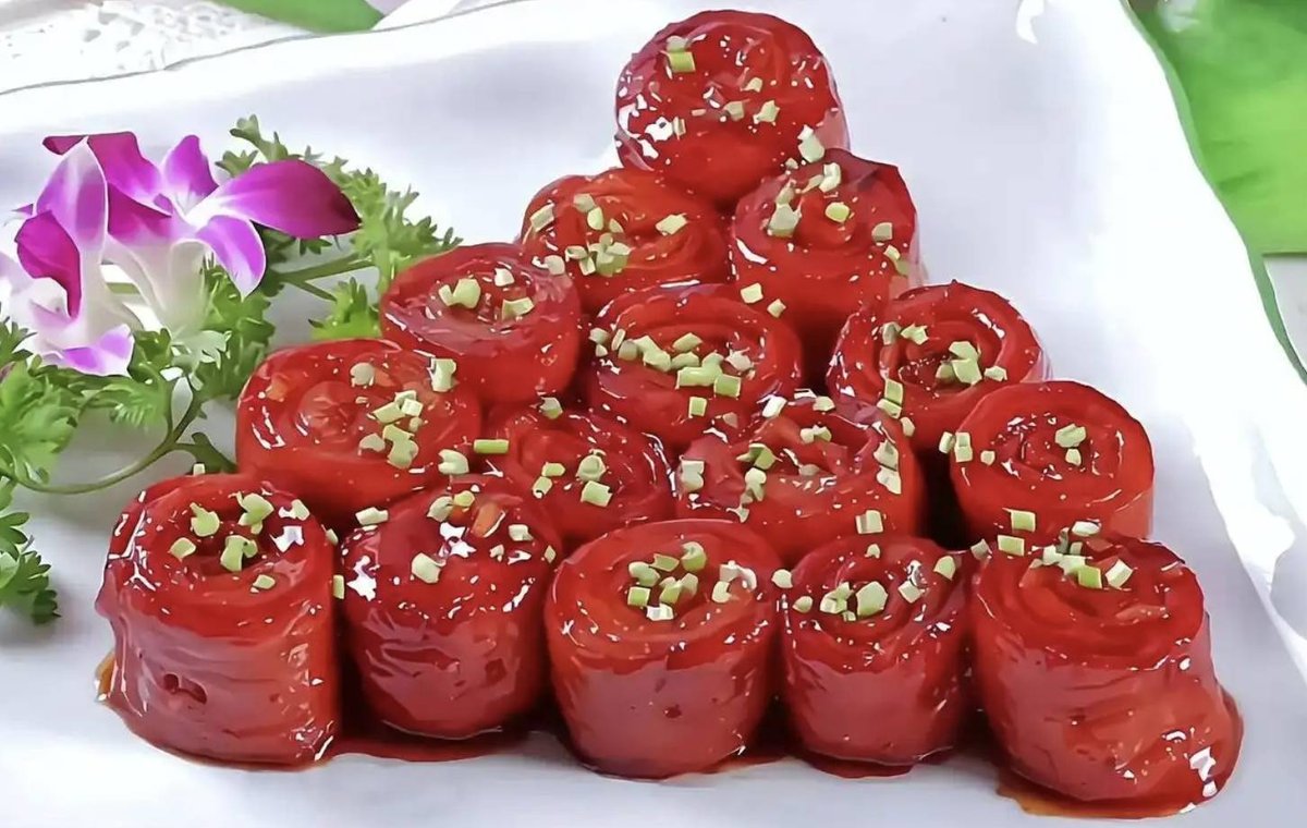 Nine-Turn Intestine — a stack of dark, glossy braised pork intestine rings on a white plate, scattered with chopped scallion