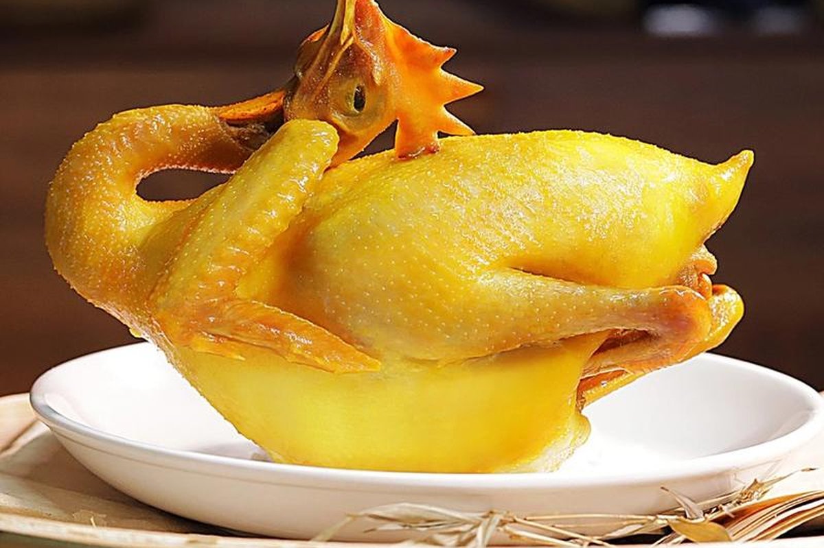 Salt-Baked Chicken — a whole golden bird, skin lacquered pale gold, resting on bamboo paper and coarse salt
