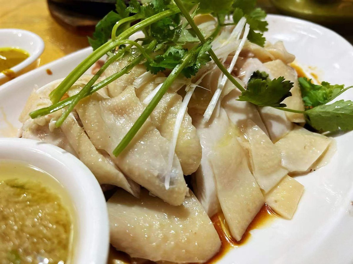 White Cut Chicken plated with ginger-scallion dipping oil on the side