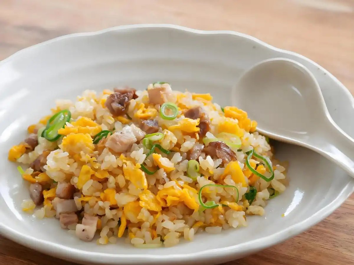 Yangzhou Fried Rice on a restaurant table — white ceramic plate, steam rising, chopsticks resting beside the dish